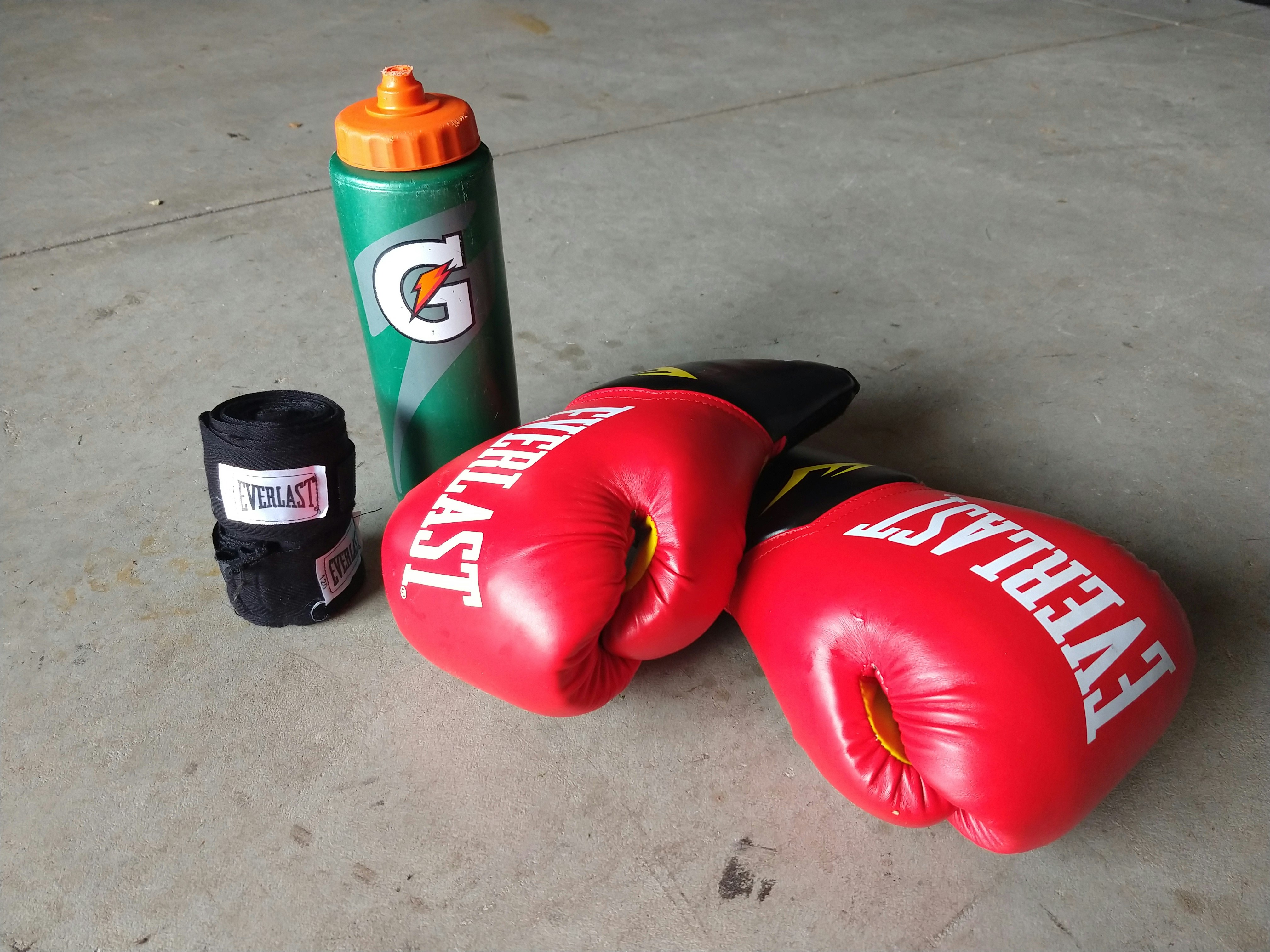 pair of red Everlast boxing gloves beside Gatorade bottle